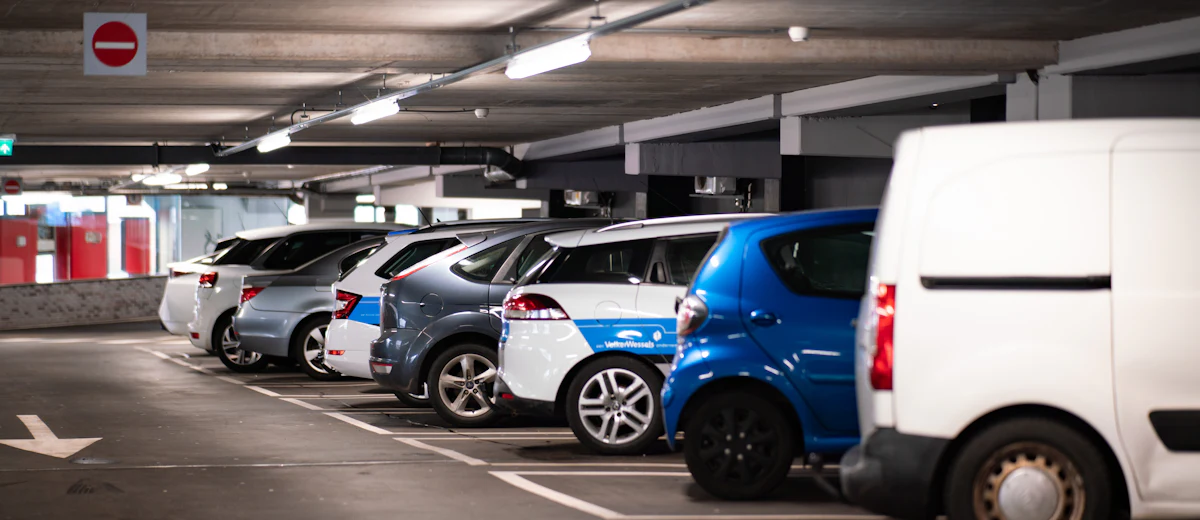 Open parking deck with cars, recoated in phases so monthly parkers keep most of their spaces