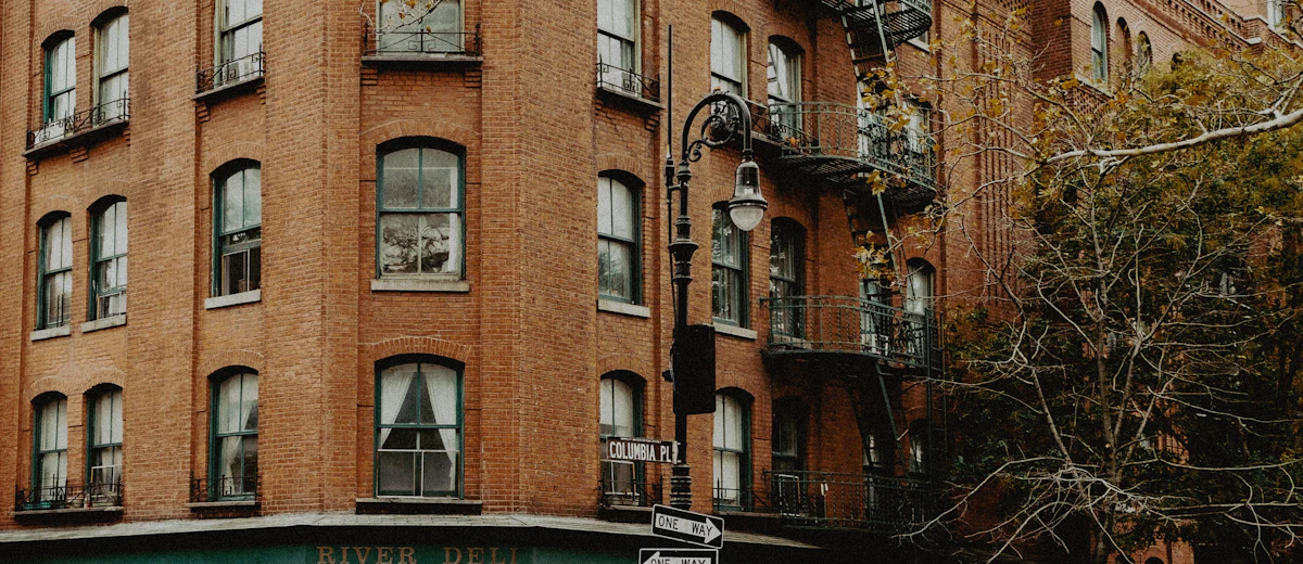 Brick apartment building facing a Brooklyn street, the kind of street-front wall whose parapet needs a yearly observation