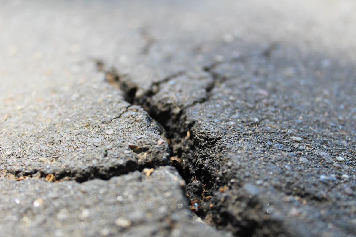 Cracked and worn deck surface where the coating has failed, typical wear on Brooklyn parking decks